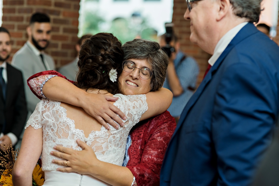 A bride hugs her mother at the end of the isle during her wedding.